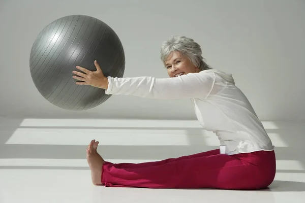 Mujer sosteniendo la bola de ejercicio — Foto de Stock