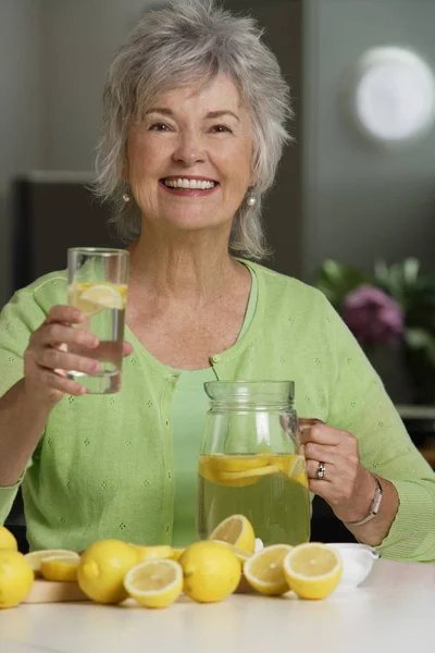 Mujer madura sosteniendo ayuda de limón — Foto de Stock