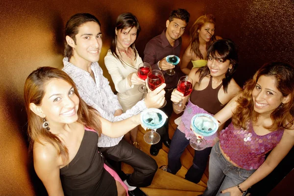 Giovani adulti che alzano bevande alla macchina fotografica — Foto Stock