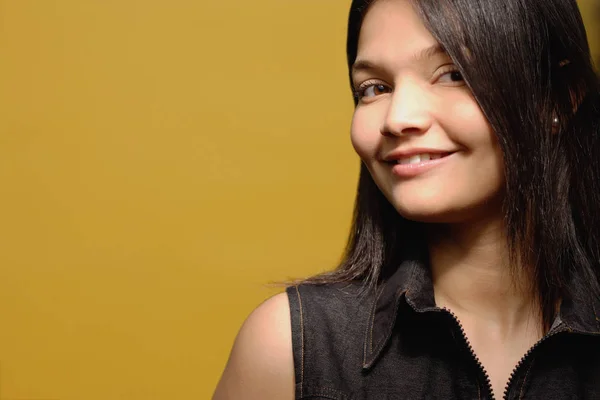 Young woman against yellow background — Stock Photo, Image