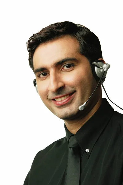 Hombre usando auriculares, sonriendo —  Fotos de Stock