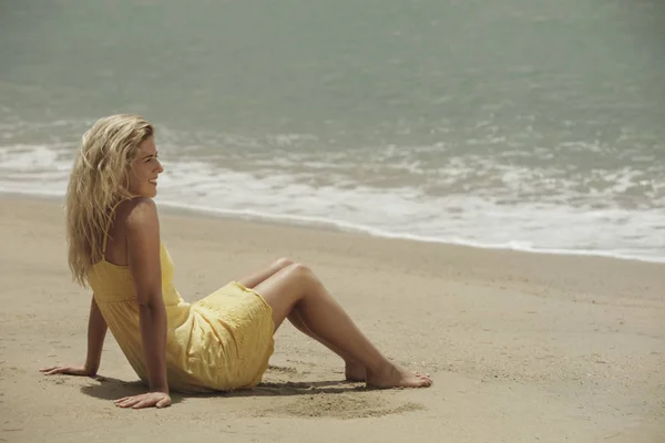Mujer sentada en la playa — Foto de Stock