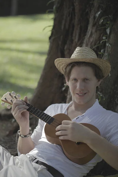 Человек играет на укулеле — стоковое фото