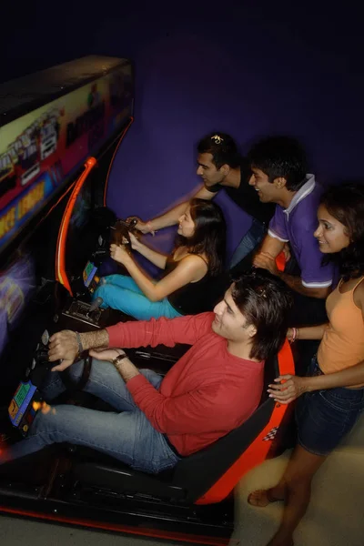 Jóvenes adultos en arcade de diversiones —  Fotos de Stock