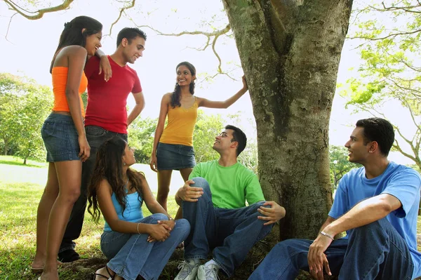 Adultos jovens sentados no parque — Fotografia de Stock