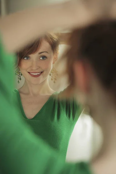 试着在镜子的耳环的女人 — 图库照片