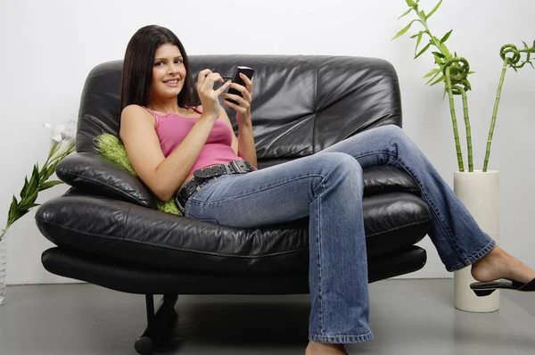 Женщина, сидящая на кресле с КПК — стоковое фото