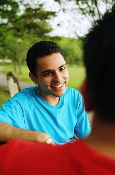 Hombre sonriendo, frente a otra persona — Foto de Stock