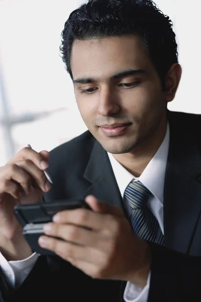 Jovem empresário usando telefone celular — Fotografia de Stock