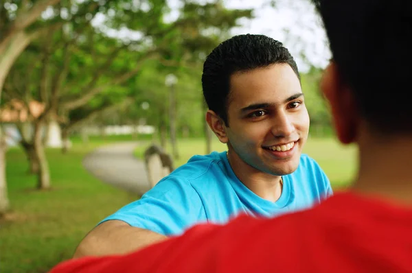 Hombre sonriendo, frente a otra persona — Foto de Stock