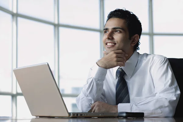 Jovem empresário sentado na frente do laptop — Fotografia de Stock