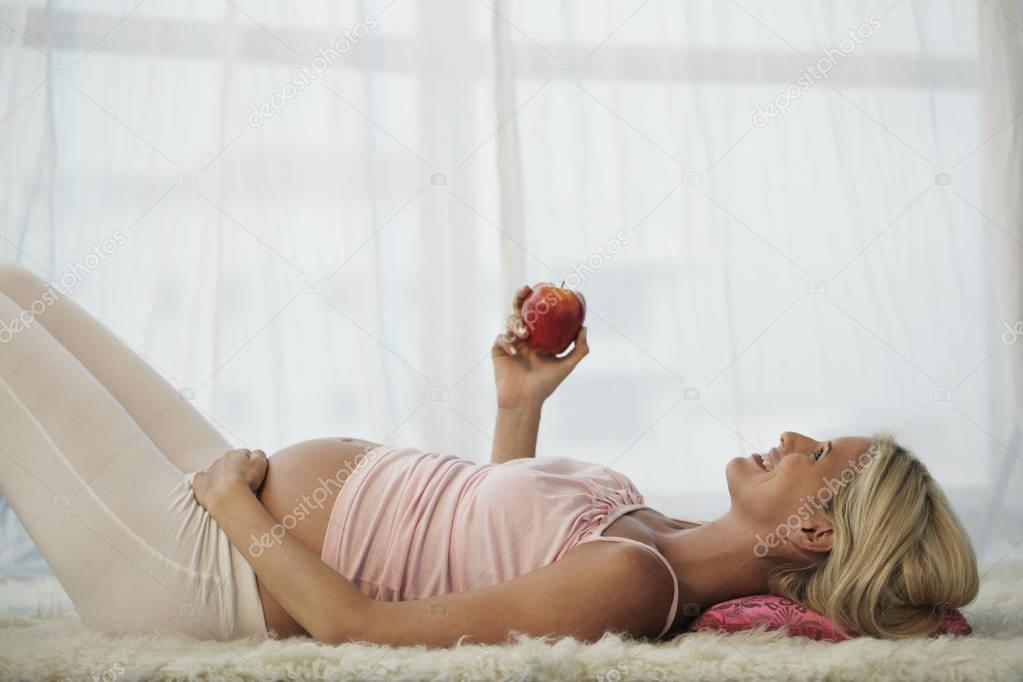 pregnant woman holding apple