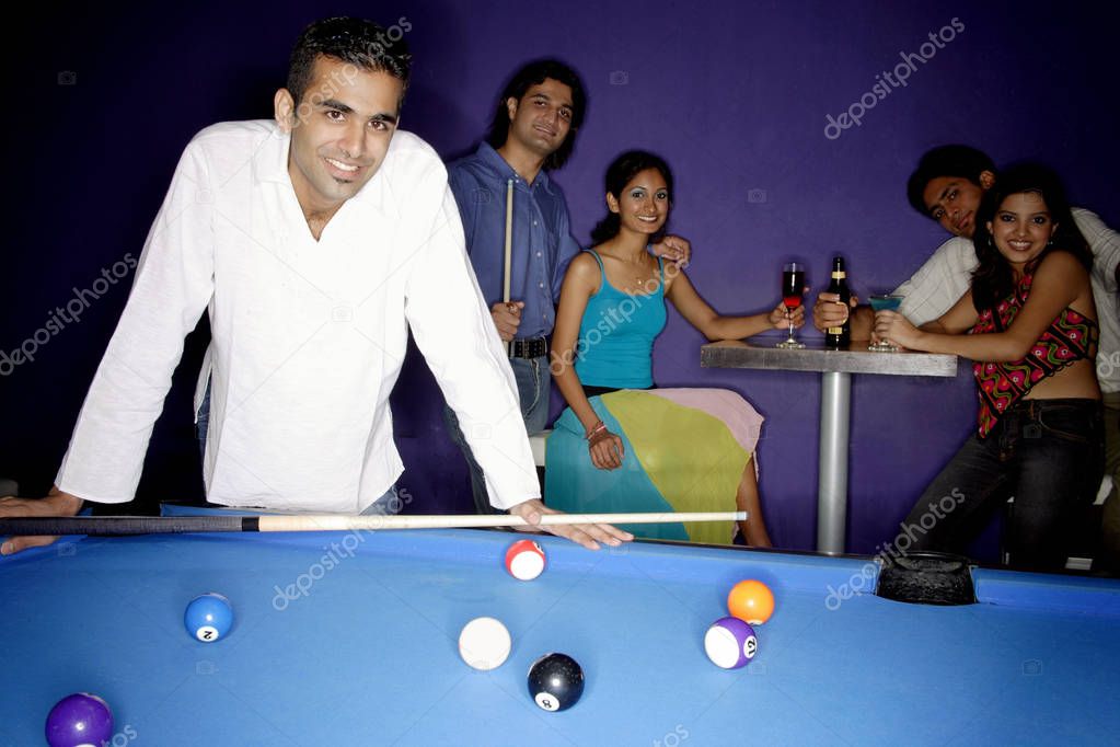 Young man standing at pool table