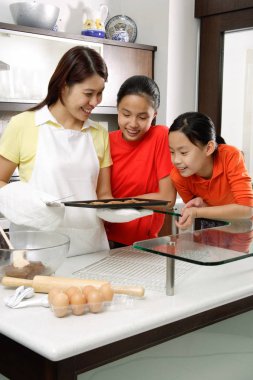 Anne ve iki kızı mutfakta