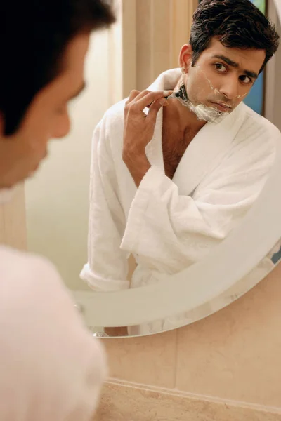 Hombre mirando en el espejo del baño — Foto de Stock