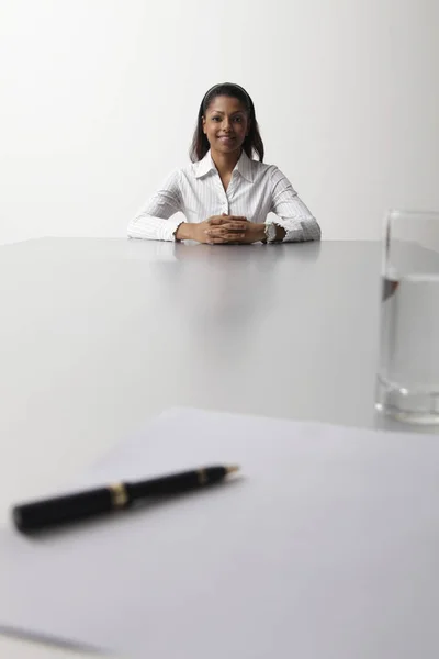 Mujer joven sentada al final de la mesa — Foto de Stock