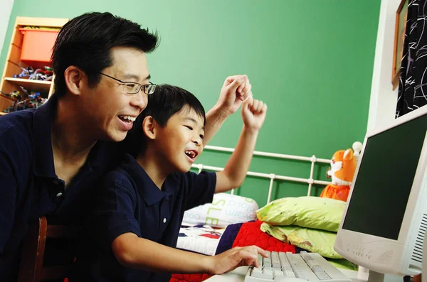 Vater und Sohn nutzen Computer — Stockfoto