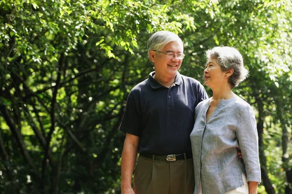Äldre par stående i park — Stockfoto