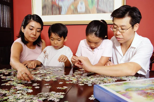 Family fixing jigsaw puzzle