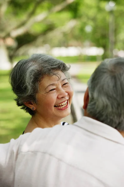 Mujer sonriendo, sobre la vista del hombro — Foto de Stock