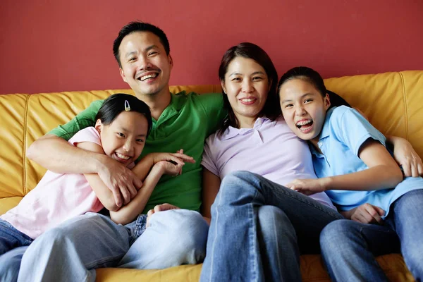 Family of four sitting on sofa