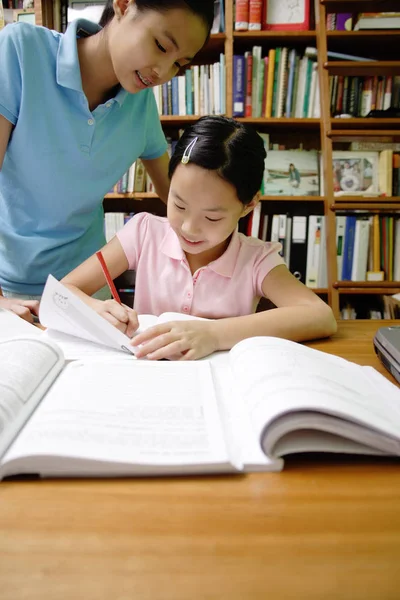 Kobieta i dziewczynka w bibliotece — Zdjęcie stockowe