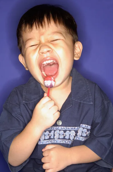 男孩吃棒棒糖 — 图库照片