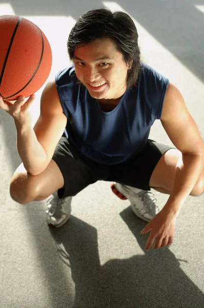 Muž pokrčený, držení basketbal — Stock fotografie