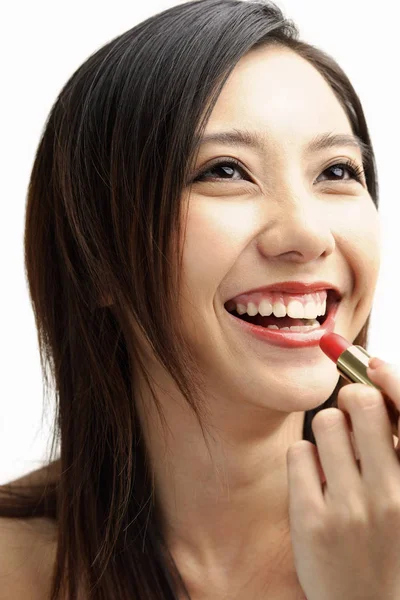 Woman putting on lipstick — Stock Photo, Image