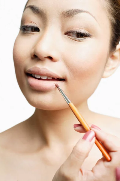 Frau benutzt Lippenstift-Pinsel — Stockfoto