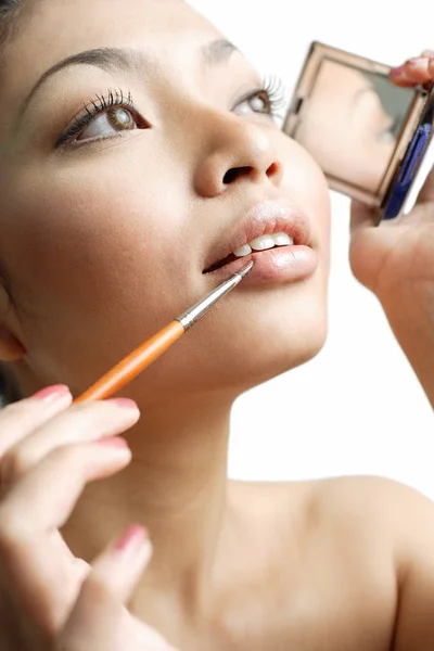 Frau benutzt Lippenstift-Pinsel — Stockfoto