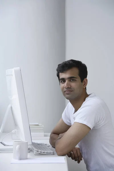Indian man working on computer.
