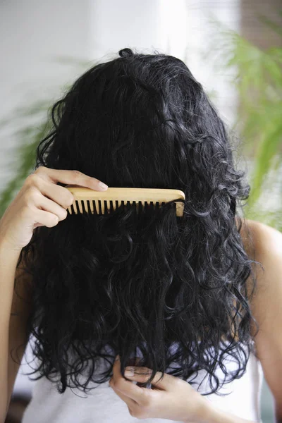 Indian woman combing her hair