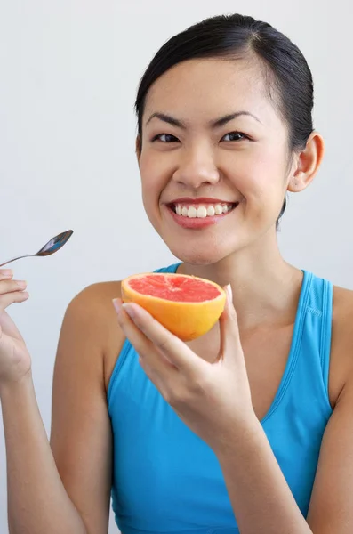 Frau mit Grapefruit und Löffel — Stockfoto