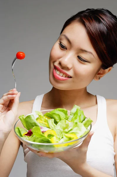 Mujer mirando tomate en tenedor — Foto de Stock