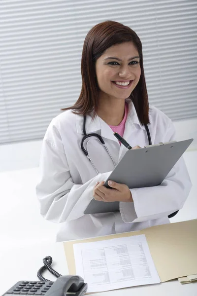 Médico sorrindo com relatório — Fotografia de Stock