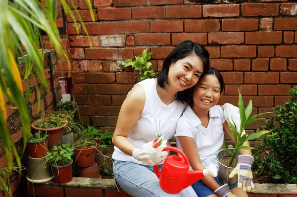 Madre e hija, sentadas en el jardín — Foto de Stock