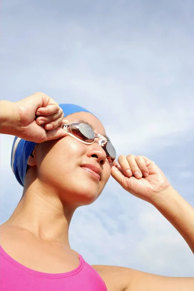 Frau justiert Schwimmbrille, schaut weg — Stockfoto