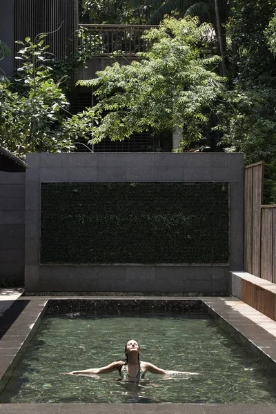 Kvinna som vilar på moderna pool — Stockfoto