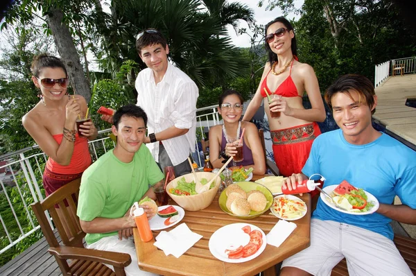 Молодые люди едят в патио — стоковое фото