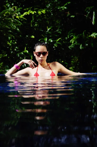Vrouw in rode bikini in zwembad — Stockfoto