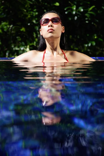 Kvinna i röd bikini i poolen — Stockfoto