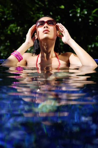 Kvinna i röd bikini i poolen — Stockfoto