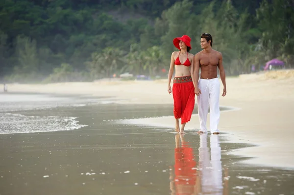 Casal andando ao longo da praia — Fotografia de Stock