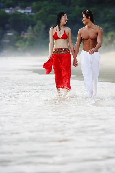 Casal andando ao longo da praia — Fotografia de Stock