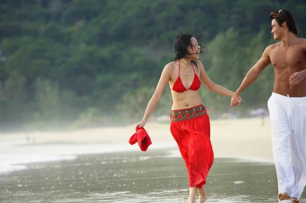 Paar spaziert am Strand entlang — Stockfoto