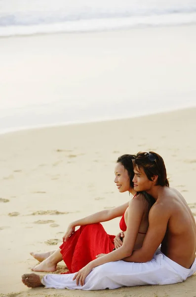 Пара сидящих на пляже — стоковое фото