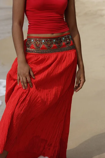 Vrouw in rode jurk op strand — Stockfoto