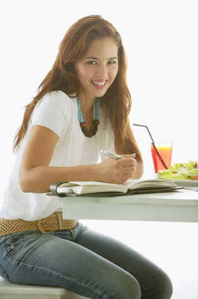 Une femme assise à table — Photo