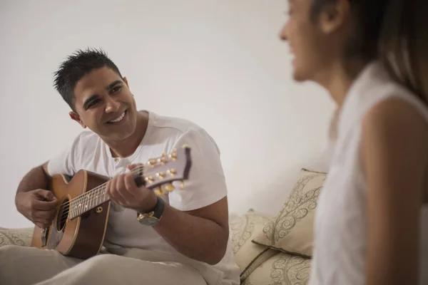 Hombre tocando la guitarra y mirando a la mujer —  Fotos de Stock